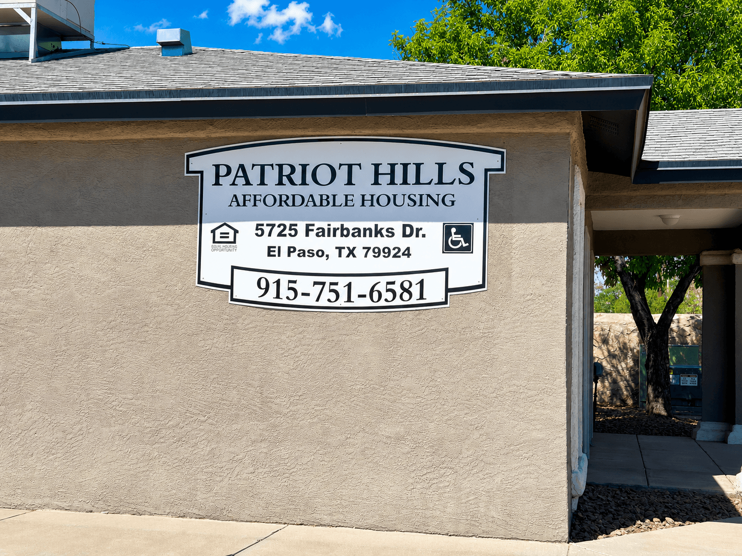 A sign for Patriot Hills Affordable Housing is on the side of a building.